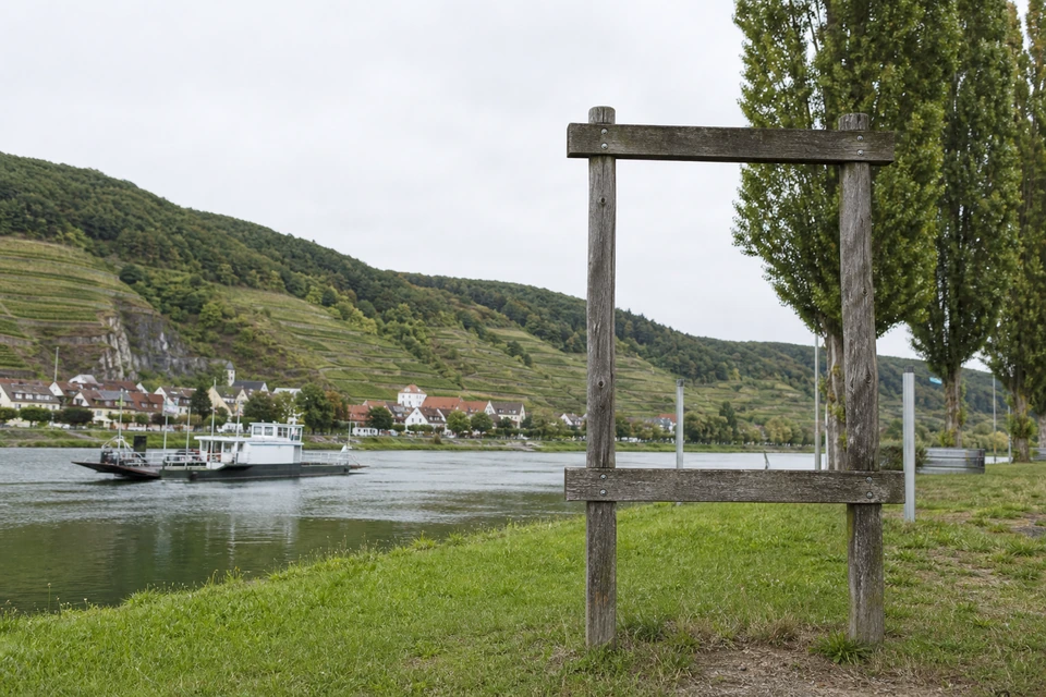 Leerer hölzerner Wegweiserrahmen ohne Beschriftung an einem Flussufer (mit AI erstelltes Bild)