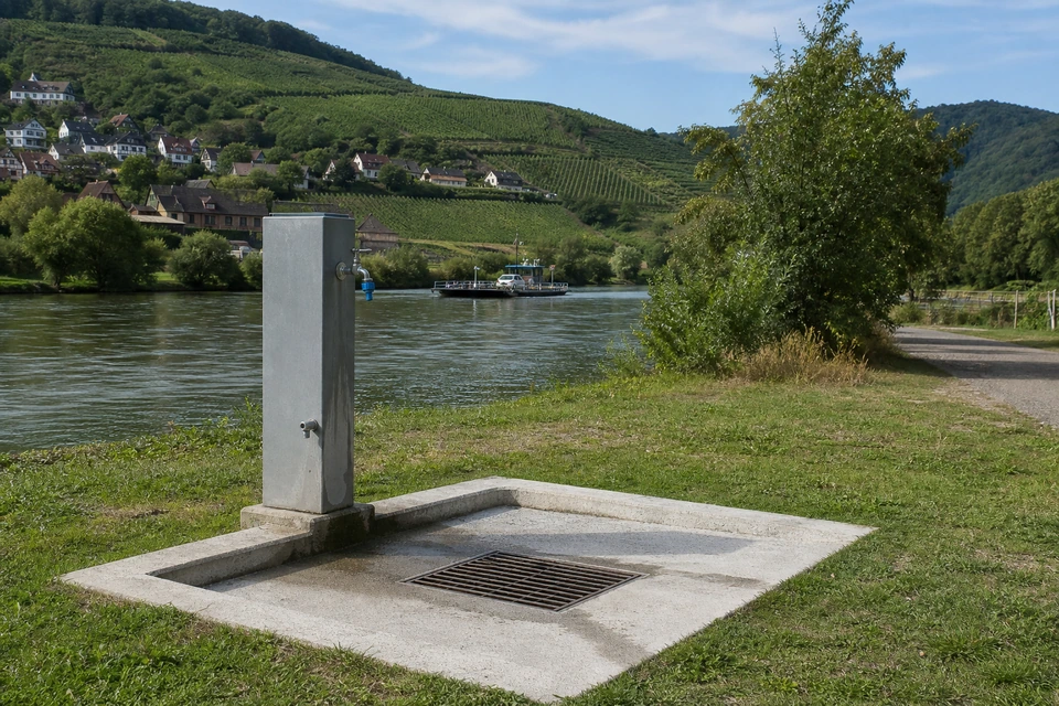 Betonierte Entsorgungsstation für Grauwasser an einem Stellplatz mit Gitterrost und Wasserhahn (mit AI erstelltes Bild)
