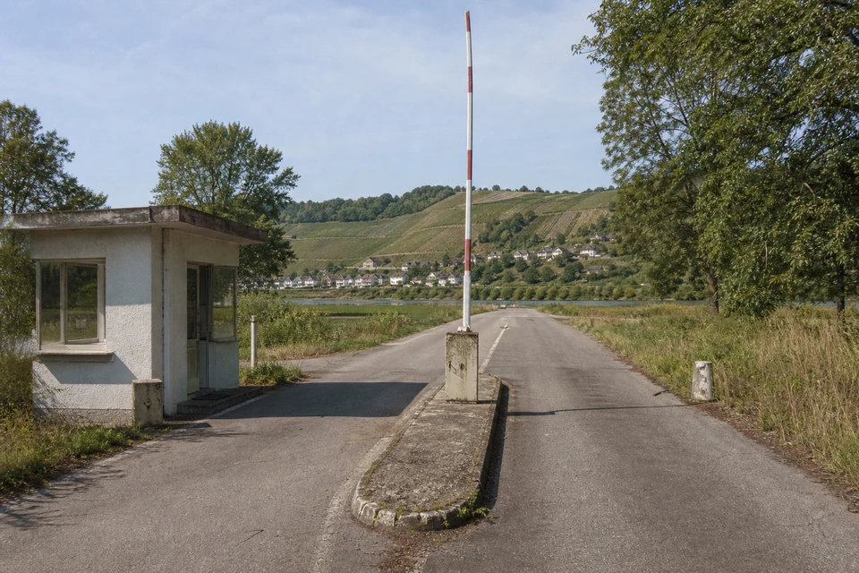 Ehemaliger Grenzübergang an einer Landstraße mit geöffneter Schranke (mit AI erstelltes Bild)