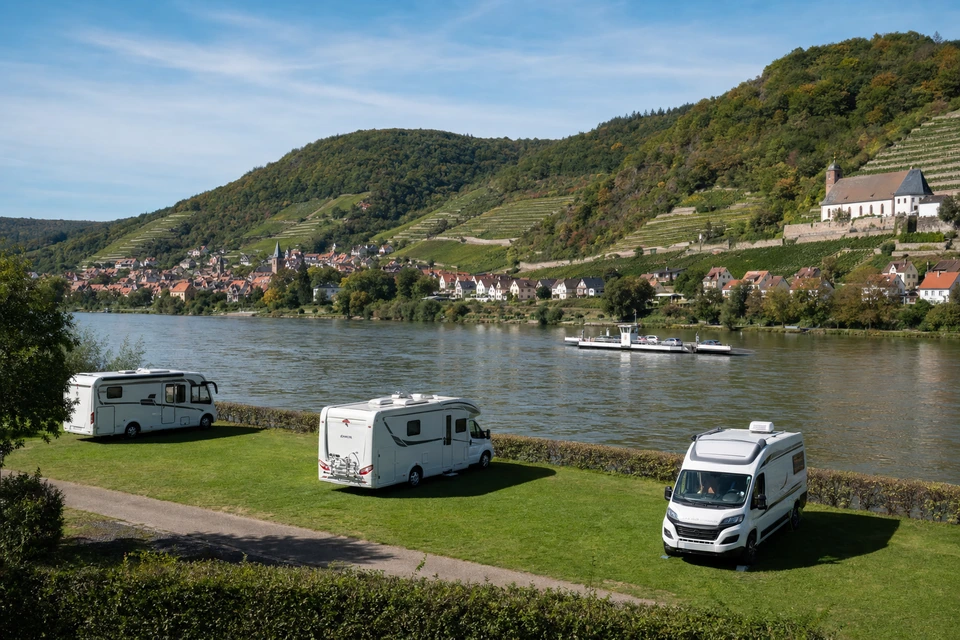 Ebene Wiesenparzelle direkt am Flussufer mit drei weißen Wohnmobilen (mit AI erstelltes Bild)